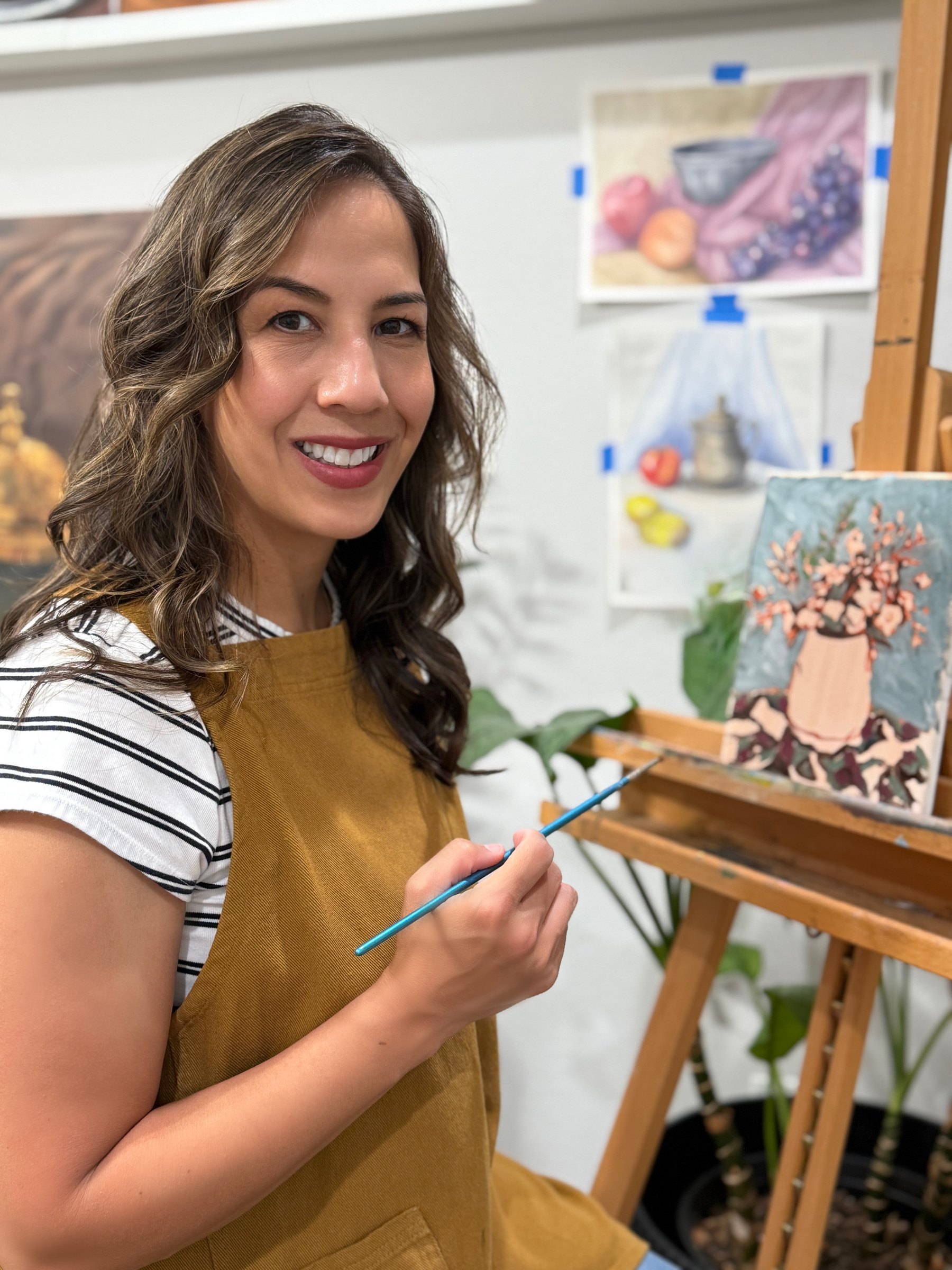 Amber Michelle painting at her easel in her studio