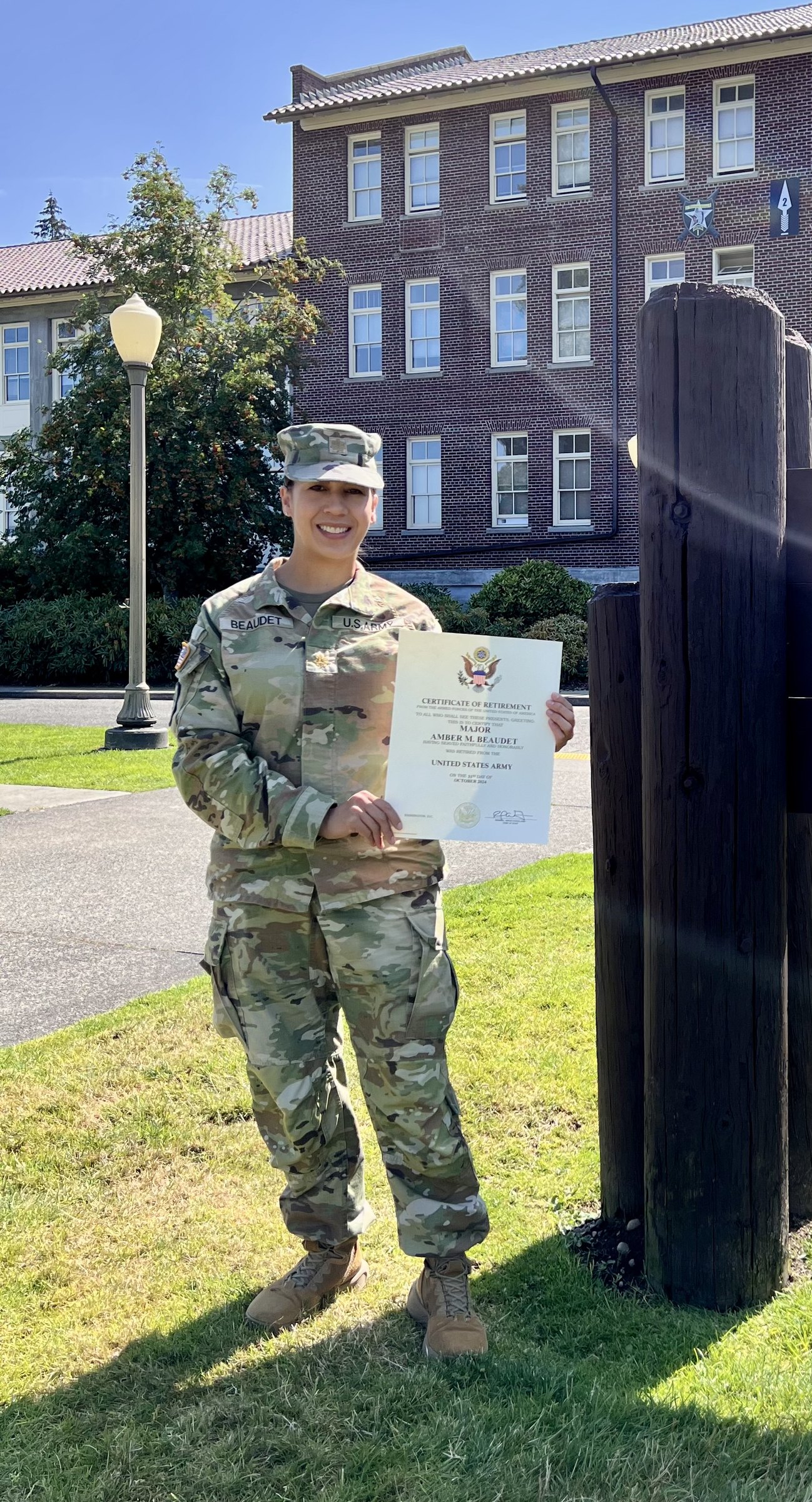 Amber Michelle in U.S. Army uniform holding her certificate of retirement